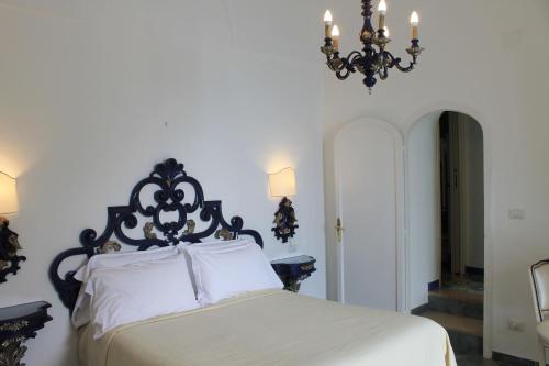 a bedroom with a black and white bed and a chandelier at Hotel Reginella in Positano