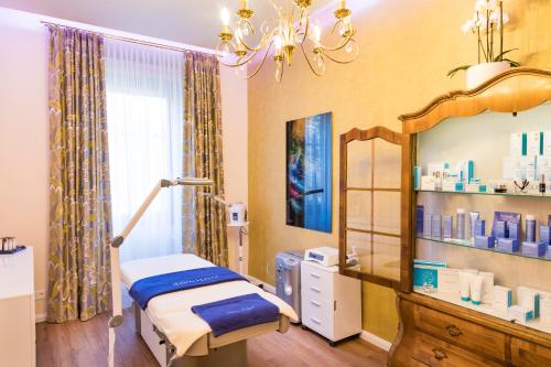 a hospital room with a bed and a chandelier at Parkhotel Graz - Traditional Luxury in Graz