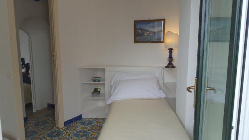 a small bedroom with a bed in a room at Hotel Reginella in Positano