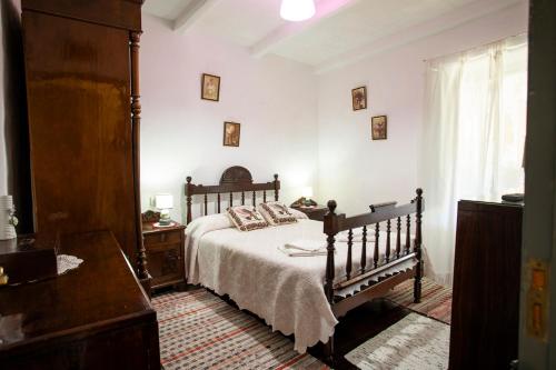 a bedroom with a bed and a dresser and a window at Pensión Santa Rosa in Samos