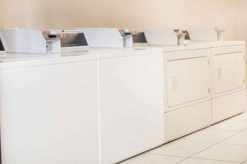 a row of white washing machines in a room at Ramada by Wyndham Enid in Enid