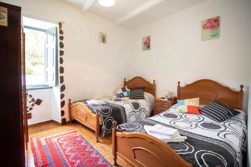 a bedroom with two beds and a window at Pensión Santa Rosa in Samos