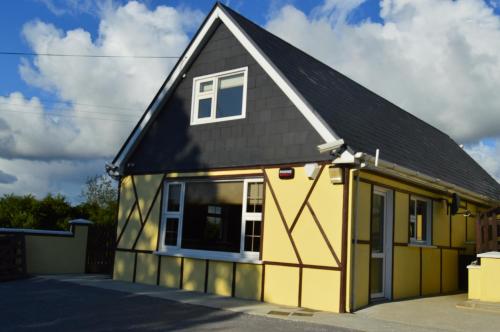 a yellow and black house with a black roof at killarney retreat in Killarney