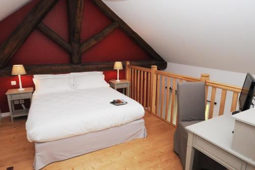 1 dormitorio con 1 cama grande y pared roja en Les Communs du Manoir, en Écully
