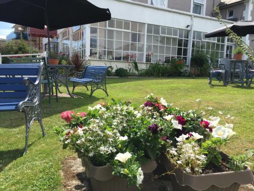 a garden with a blue bench and a bunch of flowers at Marlborough Hotel in Shanklin