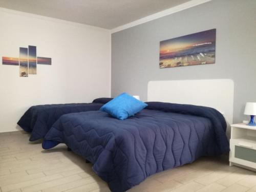 um quarto com 2 camas com almofadas azuis em B&B dal Gallo em Battipaglia