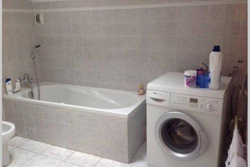 une salle de bain avec baignoire et machine à laver dans l'établissement Les Palatines Penthouse, à Saint-Raphaël