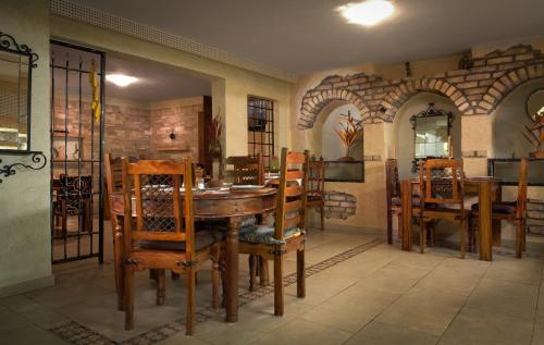 jadalnia z drewnianym stołem i krzesłami w obiekcie Villa Anri w mieście Mostar