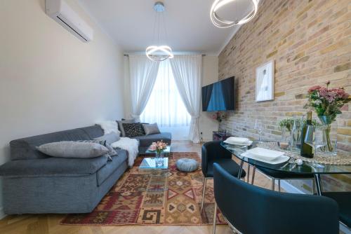 uma sala de estar com um sofá azul e uma parede de tijolos em Vista dał Mare em Split