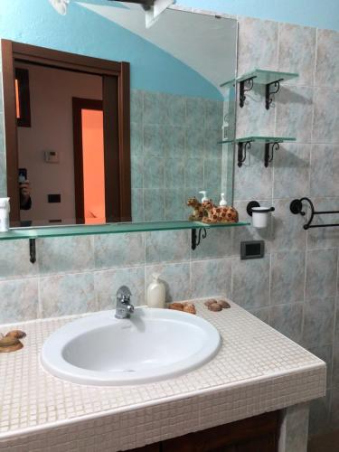 bagno con lavandino e specchio di Appartamento in centro Nus a Nus