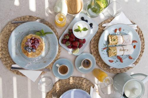 a table with plates of food and cups of coffee at Hide Out Suites in Mylopotas