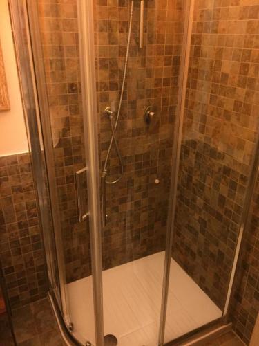 a shower with a glass door in a bathroom at Rio Groppo Guesthouse in Manarola