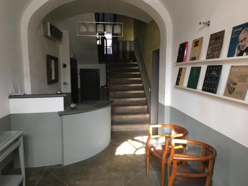 a hallway with a staircase with a chair and a table at B&B Locanda Toscanini in Cetona