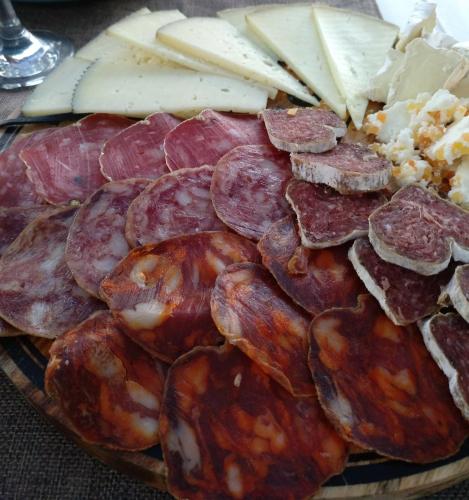 a plate of cured meats and cheese on a table at Hostal Sant Roc in Botarell