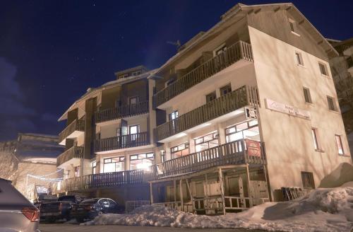 a tall building with snow in front of it at Hotel Le Beau Site in Auris