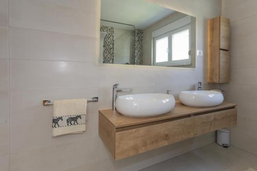 ein Badezimmer mit zwei Waschbecken und einem Spiegel in der Unterkunft LIFE - NEW and LUXURY holiday house in Kaštela