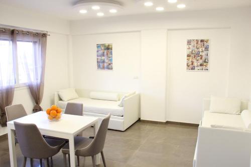a white living room with a table and a couch at Mondo Suites Apartments in Naples