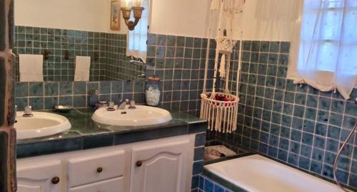 Baño de azulejos verdes con 2 lavabos y bañera en Villa l'Air du temps, en Juan-les-Pins