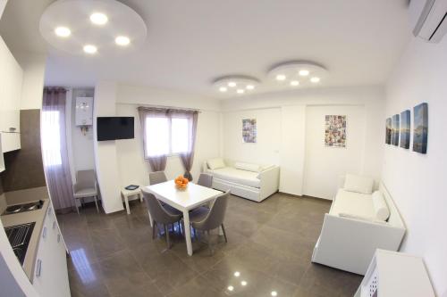 a kitchen and living room with a table and chairs at Mondo Suites Apartments in Naples