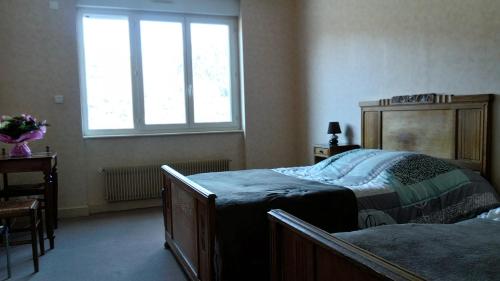 um quarto com 2 camas e uma janela em Hôtel St Joseph em Vic-sur-Cère