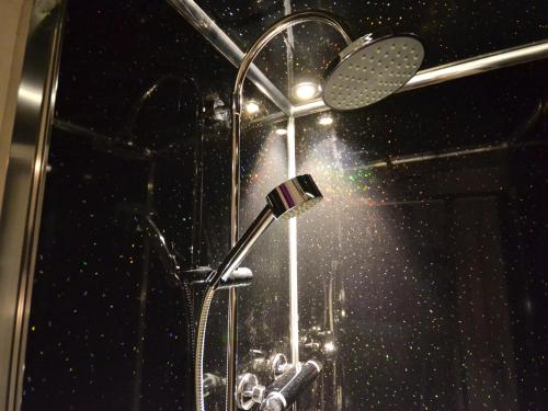 a shower with a shower head in a bathroom at South Shore Guest House in South Shields