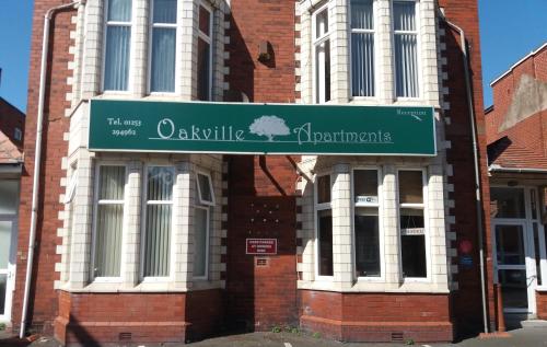 a building with a green sign in front of it at Oakville Apartments in Blackpool