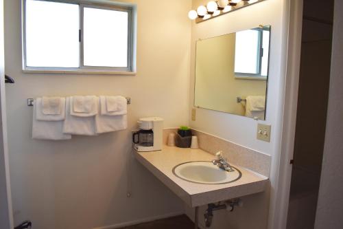 a bathroom with a sink and a mirror and towels at JR Inn in Soda Springs