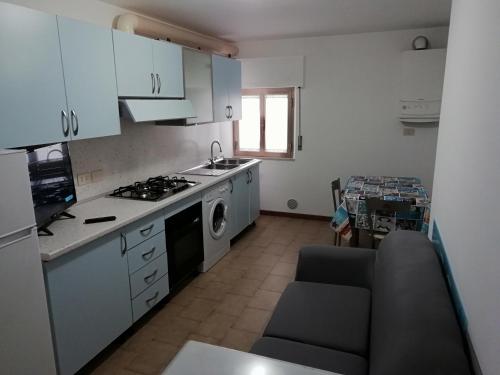 La cuisine est équipée de placards blancs et d'un four avec plaques de cuisson. dans l'établissement Casa vacanze Maria Chiara, à San Benedetto del Tronto