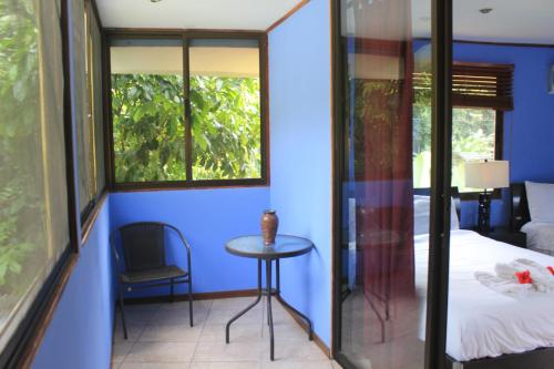 a room with a bed and a table and a window at La Posada Jungle Hotel in Manuel Antonio