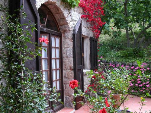 a window with flowers on the side of a building at Maison d'Hôtes de Charme de Croccano in Sartène