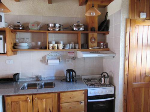 cocina con fregadero y fogones horno superior en Villa Cerro Catedral en San Carlos de Bariloche