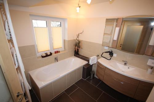 a bathroom with a large tub and a sink at Gasthof Waldwirt in Russbach am Pass Gschütt