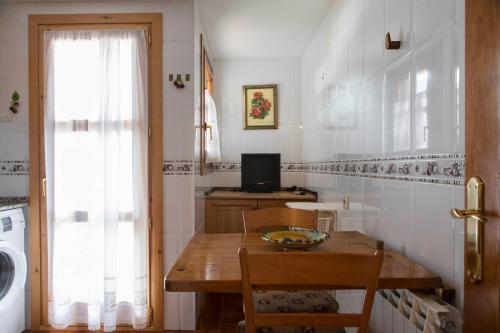 una pequeña cocina con mesa y ventana en Casa Siñantonio Benasque centro, en Benasque