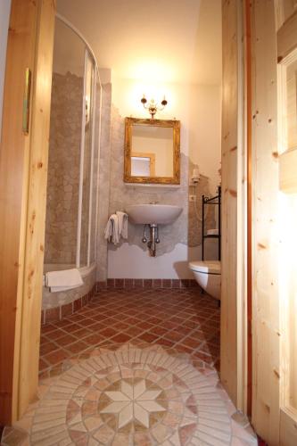 a bathroom with a sink and a toilet and a mirror at Gasthof Waldwirt in Russbach am Pass Gschütt