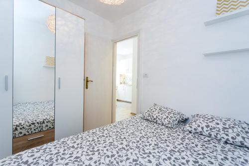 ein weißes Schlafzimmer mit einem Bett und einem Spiegel in der Unterkunft Apartment Lea Old Town in Poreč