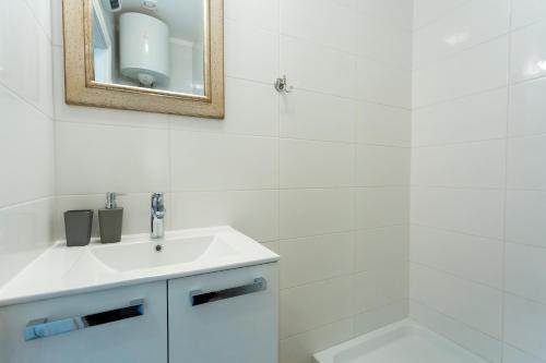 ein weißes Badezimmer mit einem Waschbecken und einem Spiegel in der Unterkunft Apartment Lea Old Town in Poreč