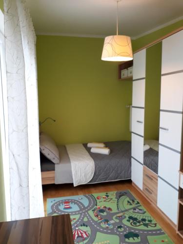 a bedroom with a bed and a green wall at House Villa Mare in Malinska