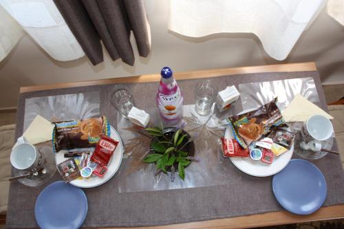 a table with two plates of food and a bottle at Thanos Studio in Artemida