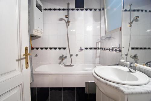 e bagno con vasca, lavandino e vasca. di Hostel Residence a Sarajevo