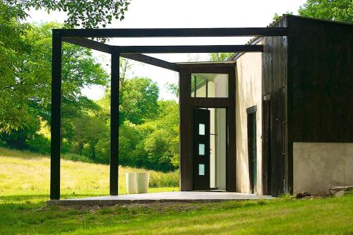 a building with an open door in a field at La grange des Palles in Vijon