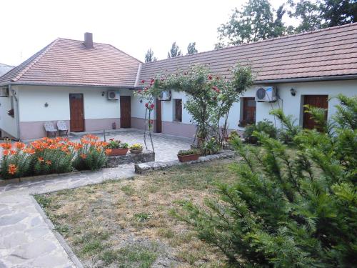 a white house with a yard with flowers at Retel Vitez Vendégház in Sárospatak