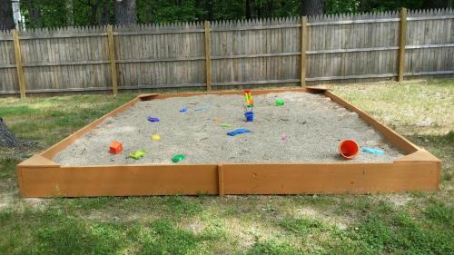 a sandbox with toys in the sand in a yard at Seabrook Inn in Seabrook