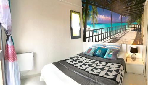 une chambre avec un lit avec un tableau sur le mur dans l'établissement Barcaresa-MAISONNETTE VUE MER PIEDS DANS L'EAU WIFI, à Port-Leucate