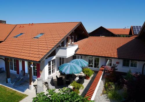 a house with a patio with an umbrella at Ferienwohnungen am Kurpark in Roßhaupten