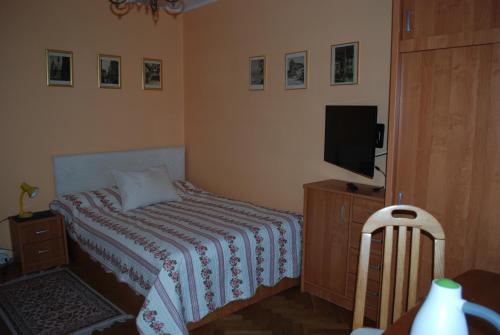 a small bedroom with a bed and a television at Homestay Kapitańska 9 in Gdynia