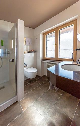 a bathroom with a tub and a toilet and a sink at Wittlers Hotel in Ratzeburg