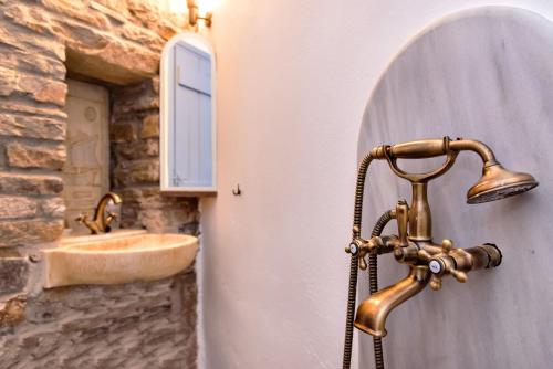een badkamer met een koperen kraan en een wastafel bij Villa Tina in Arnados