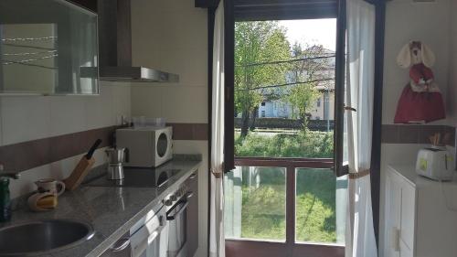 a kitchen with a sink and a window with a view at Apartamento en Nueva de Llanes in Nueva de Llanes
