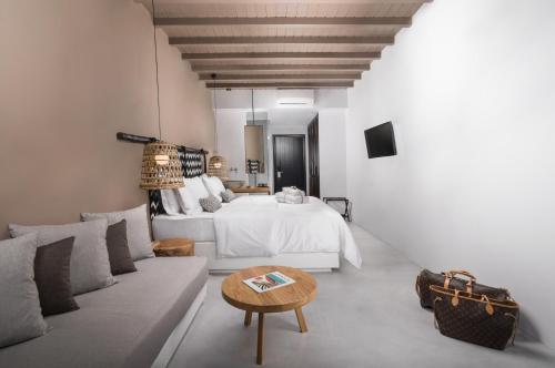a bedroom with a bed and a couch and a table at My Mykonos Hotel in Mýkonos City