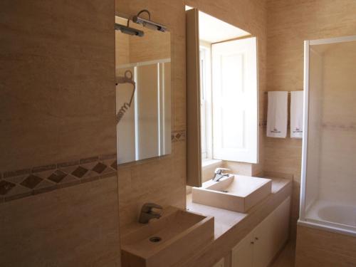 ein Bad mit einem Waschbecken und einem Spiegel in der Unterkunft Quinta do Mourão in Tentúgal
